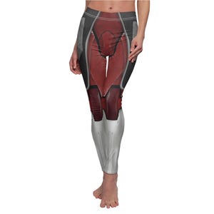 May include: Full-length leggings featuring a red and silver design with black accents. The leggings have a form-fitting silhouette and a unique, futuristic aesthetic. The design resembles a stylized armored suit.