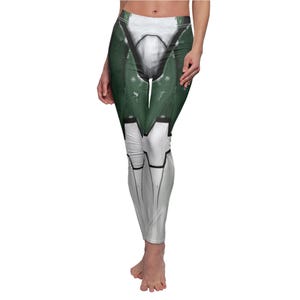 May include: White and green leggings with a detailed design. The leggings feature a design that resembles armor, with white and green panels and black accents. The leggings are form-fitting and reach the ankles.