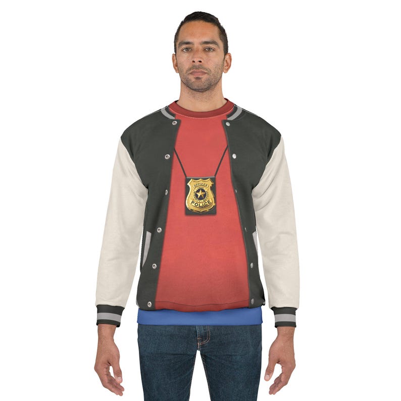 May include: A person wearing a red shirt with a gold police badge and a black and white letterman jacket. The badge is on a chain and has the words "Sergeant's Police" on it. The jacket has white sleeves and a black body.