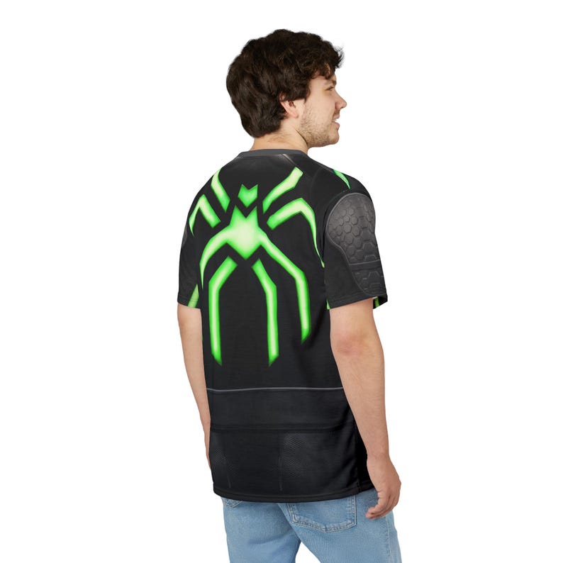 Peut inclure: T-shirt noir avec un motif d'araign&eacute;e vert n&eacute;on au dos. Le t-shirt pr&eacute;sente un d&eacute;tail d'&eacute;paule textur&eacute; et une base noire. Le motif d'araign&eacute;e vert n&eacute;on contraste fortement avec le tissu noir.