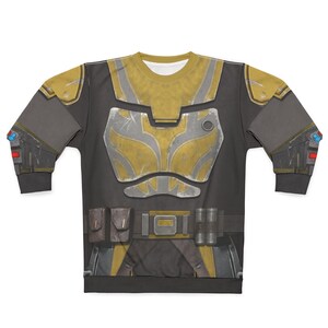 May include: A long-sleeved sweatshirt with a detailed print of a futuristic armored suit. The design incorporates shades of grey, gold, and silver, with elements resembling chest plates, shoulder pads, and utility belts. The overall aesthetic suggests a science fiction or cosplay theme.
