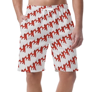 Puede incluir: Pantalones cortos de baño blancos con un patrón repetido de figuras rojas tomadas de la mano. Los pantalones cortos tienen cintura con cordón y bolsillos. El diseño es lúdico y llamativo. Perfecto para un día en la playa o la piscina.