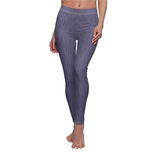 May include: Blue leggings with a textured denim-like appearance. The leggings have a high waist and a white seam detail at the waist and ankles. The fabric has a vertical grain pattern.