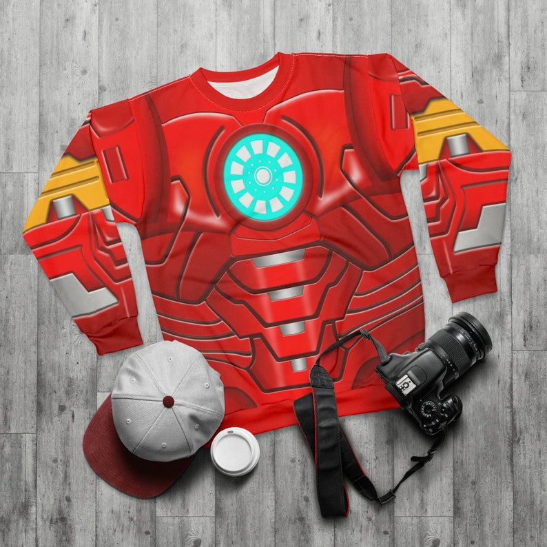 May include: Red and gold long-sleeved sweatshirt with a graphic print of Iron Man's chest armor.
