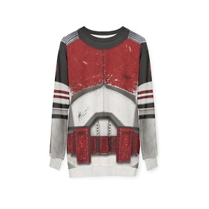 May include: A long-sleeved sweatshirt with a design that mimics a military uniform. The design features red, white, and grey panels, with red stripes on the grey sleeves. The sweatshirt has a crew neck and white cuffs. The overall style is reminiscent of a costume.