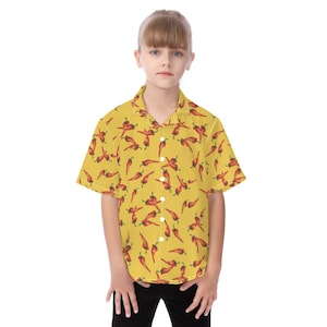 May include: A yellow button-down shirt with a red chili pepper pattern. The short-sleeved shirt is worn by a person. The shirt has a classic collar and a button-up front.