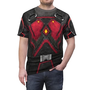 Puede incluir: Camiseta gráfica negra y roja con un diseño de armadura futurista. La camiseta presenta un patrón detallado con detalles en rojo, una forma de diamante central y un diseño de cinturón en la cintura. El diseño incluye un diamante amarillo en el centro.