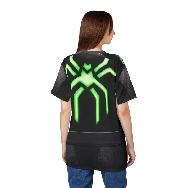 Peut inclure: T-shirt noir avec un motif d'araign&eacute;e vert n&eacute;on au dos. Le t-shirt &agrave; manches courtes a un col et des empi&egrave;cements d'&eacute;paules gris fonc&eacute;. Le motif est une araign&eacute;e stylis&eacute;e avec des lignes vertes lumineuses.
