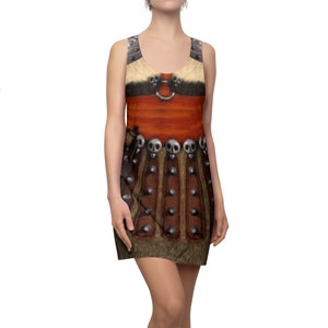Könnte beinhalten: Ein ärmelloses Kleid mit einer detaillierten Illustration von Rüstung. Das Design umfasst eine rotbraune Brustplatte, einen silbernen Ring und eine Reihe von schädelartigen Verzierungen. Das Kleid hat einen fellartigen Besatz an der Ober- und Unterseite.