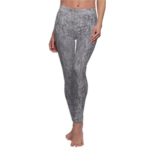Puede incluir: Leggings grises con un patrón texturizado similar a la piel. Los leggings son ajustados y llegan hasta los tobillos. La tela parece ser suave y elástica. El diseño general da la apariencia de piel animal.