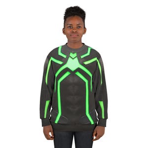 Op de afbeelding: Zwart sweatshirt met een neon groen spinnenwebontwerp over de borst en schouders. Het ontwerp heeft een gloeiend effect. Het sweatshirt wordt door een persoon gedragen.