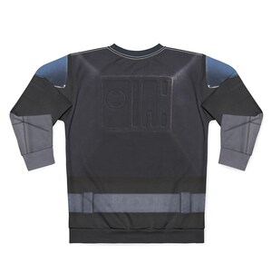 Puede incluir: Sudadera negra de manga larga con un dise&ntilde;o texturizado. La sudadera presenta una combinaci&oacute;n de colores gris oscuro y azul con un dise&ntilde;o rectangular en la espalda. Las mangas tienen paneles grises. El cuello tiene costuras blancas.