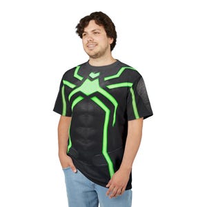 Peut inclure: T-shirt noir avec un motif d'araign&eacute;e vert sur la poitrine et les &eacute;paules. Le t-shirt a un aspect textur&eacute; et est port&eacute; par une personne en jean bleu.