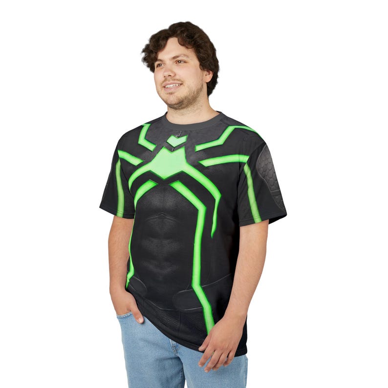 Peut inclure: T-shirt noir avec un motif d'araign&eacute;e vert sur la poitrine et les &eacute;paules. Le t-shirt a un aspect textur&eacute; et est port&eacute; par une personne en jean bleu.
