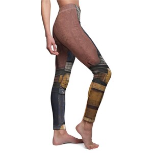 K&ouml;nnte beinhalten: Leggings mit einem braunen, blauen und gelben Design. Die Leggings weisen einen detaillierten Aufdruck auf, der einer R&uuml;stung oder einem &auml;hnlichen strukturierten Material &auml;hnelt. Das Design bedeckt die gesamte L&auml;nge der Leggings und sorgt f&uuml;r einen einzigartigen und auff&auml;lligen Look.