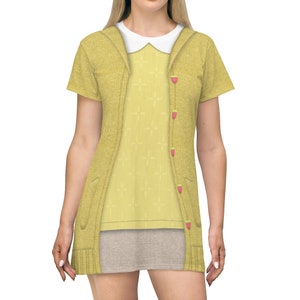 May include: A yellow short-sleeved dress with a cardigan and a white collared shirt underneath. The dress has a pattern of small crosses and buttons with red strawberries on them.