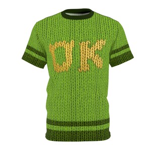 K&ouml;nnte beinhalten: Gr&uuml;nes T-Shirt im Strick-Look mit den Buchstaben "DK" in Gold. Das Shirt hat dunkelgr&uuml;ne Streifen an den &Auml;rmeln und am Saum. Der Kragen ist dunkelgr&uuml;n.