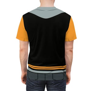 May include: A black t-shirt with a grey and orange design. The shirt has a grey collar and a grey stripe across the chest. The orange design is on the sleeves and the bottom of the shirt.