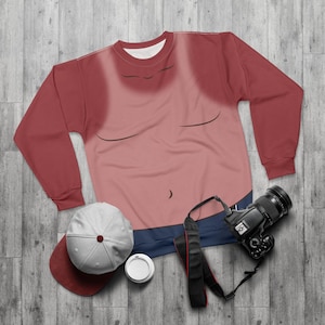 Op de afbeelding: Een rood en roze sweatshirt met een cartoon torso ontwerp. De sweatshirt heeft een ronde hals en lange mouwen. Een baseballpet, koffiekopje en camera zijn ook zichtbaar.