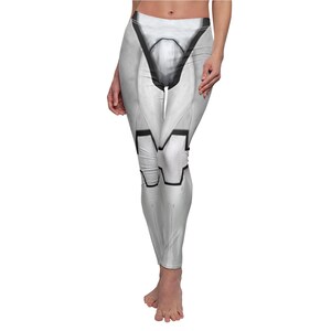 May include: White leggings with a black and gray design. The leggings feature a detailed pattern resembling armor plating, with black outlines defining the shapes. The design covers the front of the leggings, creating a futuristic look.