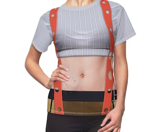 Könnte beinhalten: Ein weißes T-Shirt mit kurzen Ärmeln und einem bedruckten Design eines weiblichen Torsos, der Hosenträger trägt. Die Hosenträger sind rot mit weißen Punkten und haben einen braunen Gürtel.