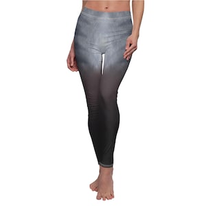Pode incluir: Leggings cinza e pretos com design gradiente. As leggings fazem a transição de cinza claro no topo para preto sólido na parte inferior. As leggings têm cintura alta e são justas.
