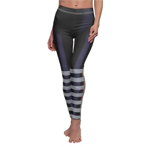 May include: Dark gray leggings with vertical stripes at the ankles. The leggings have a high waist and a subtle sheen. The stripes are a lighter gray, creating a contrasting pattern. The leggings are form-fitting and appear to be made of a stretchy material.
