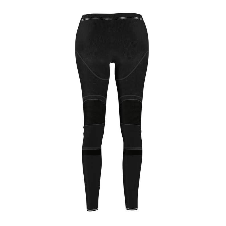 Puede incluir: Leggings negros con paneles de malla en las rodillas y la parte inferior de las piernas. Los leggings tienen una cintura alta y un detalle de rayas blancas en la parte superior e inferior de las piernas. La tela parece ser el&aacute;stica.