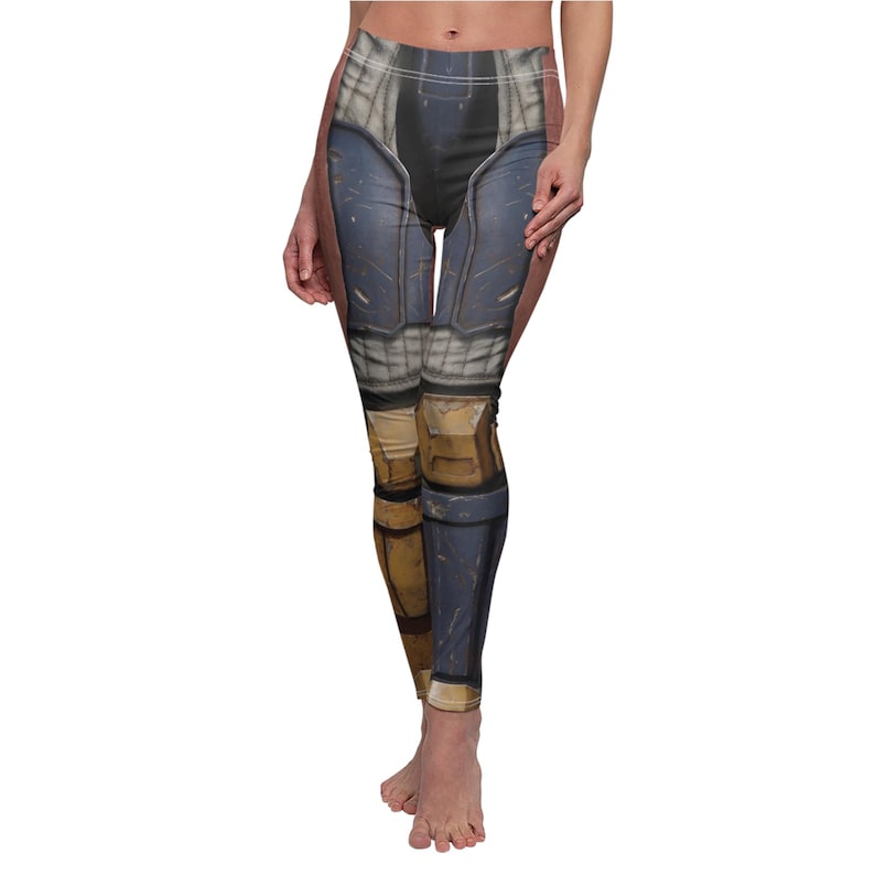 K&ouml;nnte beinhalten: Leggings mit einem aufgedruckten Design, das einer R&uuml;stung &auml;hnelt. Die Leggings weisen Farbt&ouml;ne von Blau, Grau und Beige auf, mit Details, die das Aussehen von Metallplatten und Schutzkleidung nachahmen. Das Design bedeckt die gesamte L&auml;nge der Leggings.