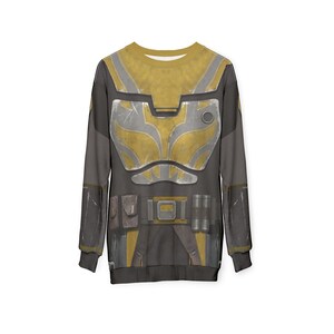 May include: A long-sleeved sweatshirt with a detailed armour design. The design uses yellow, grey, and black, with a belt and pouches. The overall aesthetic suggests a futuristic or sci-fi theme.