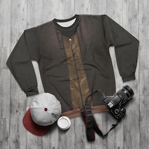 May include: A black sweatshirt with a brown leather jacket print. The sweatshirt has a zipper detail and a brown collar.