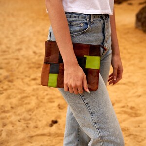 Puede incluir: Un bolso de mano de cuero marrón y verde con un diseño de patchwork y cierre de cremallera.