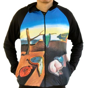 May include: A black zip-up jacket featuring a colourful print of Salvador Dali's "The Persistence of Memory" painting. The print includes melting clocks, a tree, and a desert landscape.