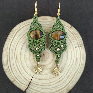 Könnte beinhalten: Ein Paar grüne Makramee-Ohrringe mit goldenen Akzenten und Tigerauge-Steinen.