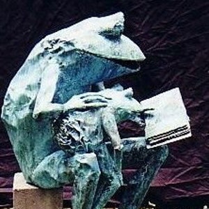 Human sized parent and child copper frogs reading a book