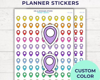 May include: Sheets of planner stickers featuring colorful pin locators in a rainbow of hues. The stickers are arranged in rows and columns, with two larger purple pin locators in the center. Text at the top reads "PIN LOCATOR PLANNER STICKERS". A green circle says "CUSTOM COLOR OPTION".