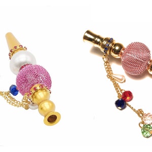 May include: Ornate hookah mouthpieces with gold-colored metal, pink mesh spheres, and dangling chains with colorful beads. One mouthpiece has a white pearl-like bead. The designs feature jewel-like accents.