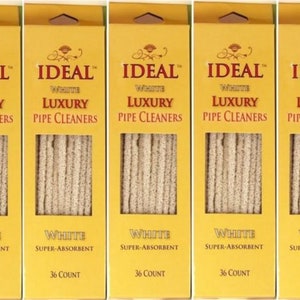 May include: Five boxes of "IDEAL White Luxury Pipe Cleaners" are displayed. Each box is yellow with the product name in a decorative font. The boxes contain white, super-absorbent pipe cleaners, with 36 count per box.