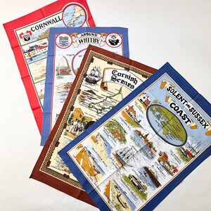 May include: Four colorful vintage tea towels with travel-themed designs. Each towel features a different location: Cornwall, Around Whitby, Cornish Scenes, and Solent and Sussex Coast. The towels have a map and illustration design.
