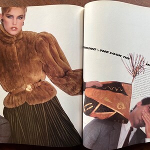 Puede incluir: Una mujer lleva una chaqueta de piel marr&oacute;n con un cintur&oacute;n de hebilla dorada y una falda plisada verde. El texto "Striking - The Look, The Impact" es visible en el fondo.