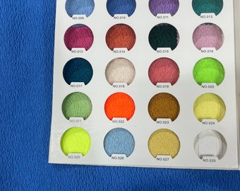 May include: A color chart with 28 fabric swatches, each labeled with a number. The swatches are arranged in four rows of seven. The swatches are a variety of colors, including red, orange, yellow, green, blue, purple, and brown.