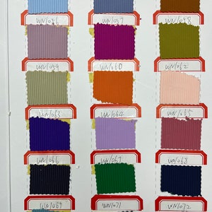 Op de afbeelding: Een kleurenkaart met stofstalen in verschillende kleuren en texturen. De stalen zijn gelabeld met nummers, zoals WN/053, WN/054, WN/055, WN/056, WN/057, WN/058, WN/059, WN/060, WN/061, WN/062, WN/063, WN/064, WN/065, WN/066, WN/067, WN/068, WN/069, WN/070, WN/071 en WN/072.