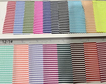 May include: A fabric swatch book with 19 different striped fabric samples. The swatches are arranged in two rows, with the top row labeled 1-11 and the bottom row labeled 12-1#. The swatches are all white with different colored stripes.