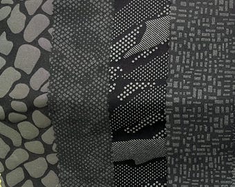 May include: Four fabric samples with varied designs. The first displays a dark grey, organic, irregular pattern. The second has a small, textured, diamond-like design. The third features a dotted and striped pattern. The fourth has a rectangular grid pattern.