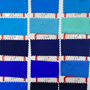 May include: A fabric swatch color chart featuring fifteen rectangular samples with pinked edges, arranged in five rows and three columns. Each swatch is labeled with a number from 52# to 66#, displaying various shades of blue, navy, and teal.