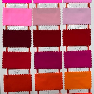 May include: A color swatch chart featuring eighteen rectangular fabric samples with pinked edges, arranged in six rows and three columns. Each sample is labeled with a number from 16# to 33#, displaying a spectrum of pink, red, and orange shades.