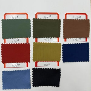 May include: A collection of eight rectangular fabric swatches with pinked edges, arranged in rows. Each swatch is labeled with a handwritten number from 103# to 110#. The colors include sage green, olive, brown, dark red, mustard, navy, blue, and black.