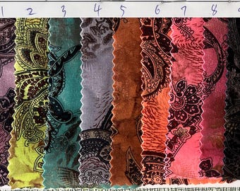 May include: Nine fabric swatches with a paisley pattern in a range of colours. The swatches include purple, yellow, teal, grey, brown, orange, pink, and black. Each swatch has a unique colour and design.