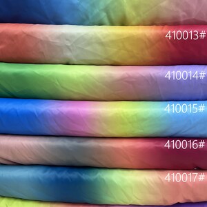 May include: A stack of six ombre spandex fabric swatches in various colors, including blue, green, yellow, pink, and red. Each swatch is approximately 40 cm wide and 35 cm long. The swatches are labeled with numbers 410012 through 410018.