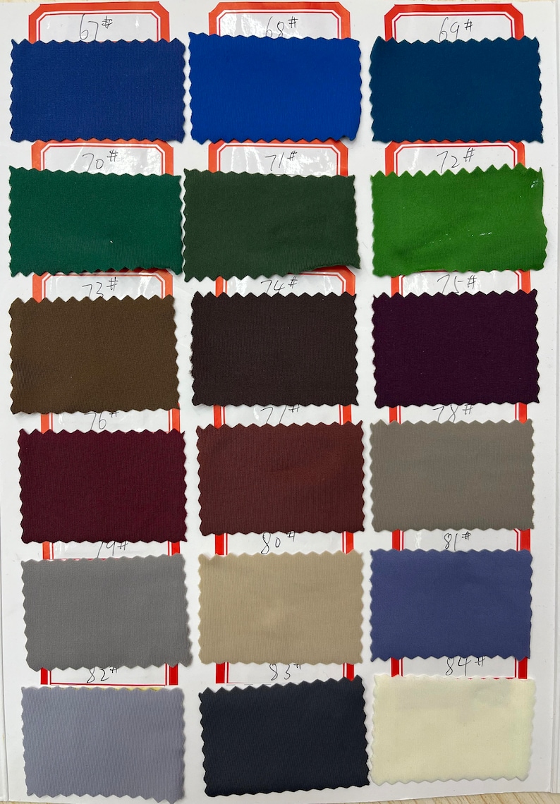May include: A fabric swatch color chart featuring eighteen rectangular samples with pinked edges, arranged in a grid. Each swatch is labeled with a number from 67# to 84# in black ink, showcasing a diverse palette of blue, green, brown, purple, gray, and cream tones.